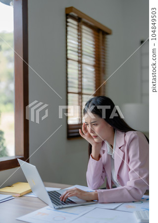 Portrait of business owner, woman using computer and financial statements Anxious expression on expanding the market to increase the ability to invest in business. 104849503