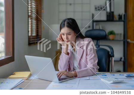 Portrait of business owner, woman using computer and financial statements Anxious expression on expanding the market to increase the ability to invest in business. Portrait of business owner, woman using computer and financial statements Anxious expression on expanding the market to increase the ability to invest in business. 104849538
