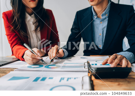 Two business people meeting to talking or discuss marketing work in workplace using paperwork, calculator, computer to work. 104849633