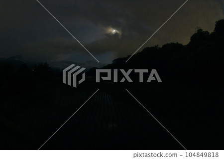 Takekawa-cho, Hokuto City, a moon with a moon age of 4.9, which is tilted to the west, is reflected in the rice paddies that have already been planted. 104849818