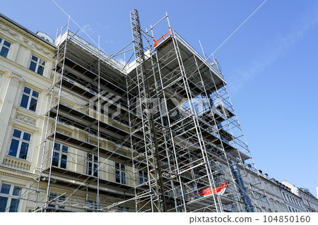 Restoration of the facade of a historic house using scaffolding with temporary elevator 104850160