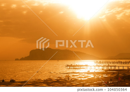 Evening, Alanya, sunset over the sea and mountains, beach and piers, Alanya, Turkiye, May 2023. 104850364