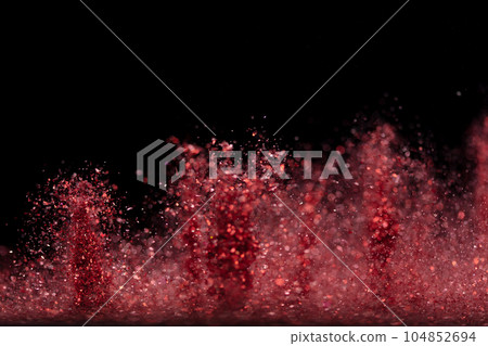 Explosion metallic red glitter sparkle. rose Glitter powder spark blink celebrate, blur foil explode in air, fly throw red glitters particle. Black background isolated, selective focus Blur bokeh 104852694