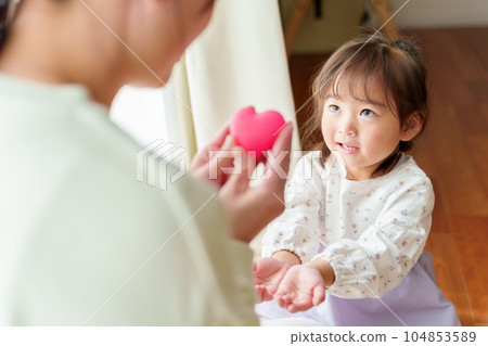 mother giving heart to girl mother giving heart to girl 104853589