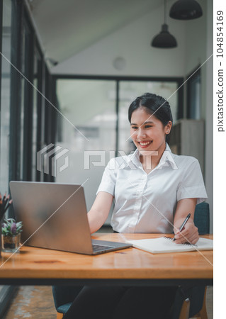 Confidence Businesswoman looking on laptop computer and smiling sitting in conference room. Confidence Businesswoman looking on laptop computer and smiling sitting in conference room. 104854169