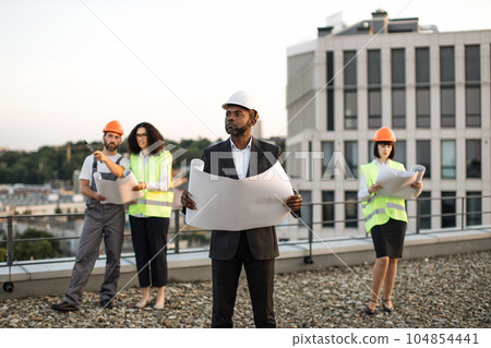 Diverse architects meeting in open air for plan discussion 104854441