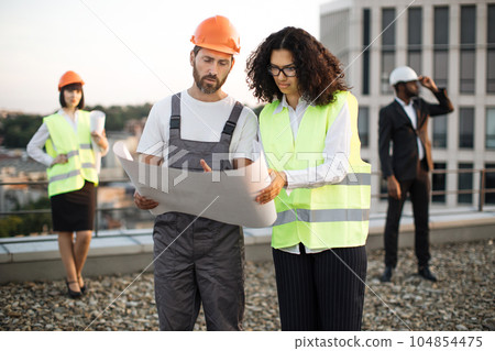 International team of urban planners examining building site 104854475