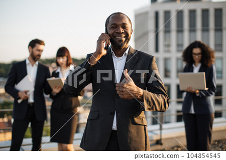 African american man talking on smartphone during meeting 104854545