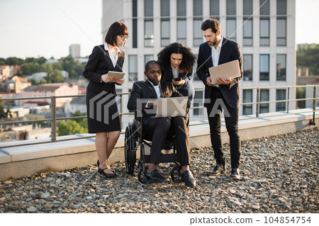 Multiracial colleagues viewing business plan on laptop Multiracial colleagues viewing business plan on laptop 104854754