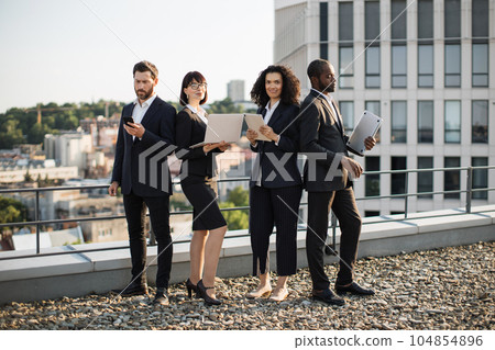 Corporate partners operating modern gadgets on rooftop Corporate partners operating modern gadgets on rooftop 104854896