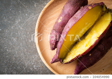 Grilled or baked Japanese sweet potatoes on wood plate 104854990