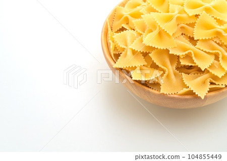 Dry uncooked farfalle pasta on white background Dry uncooked farfalle pasta on white background 104855449