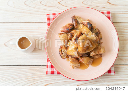 grilled bananas with coconut caramel sauce 104856047