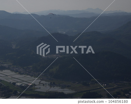 大分縣久須郡久須町山田上空飛行的滑翔傘 104856180