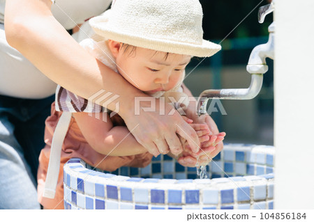 Babies having their hands washed by mom Outdoor Park Zoo 104856184