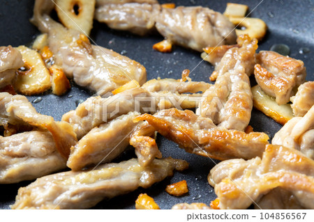 Stir-fried neck and garlic. A cooking scene where chicken (young chicken seseri) and garlic are fried in a frying pan. 104856567