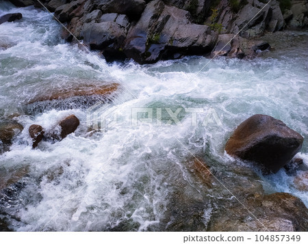 Streaming water in a mountain river, close-up of stones 104857349