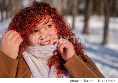 Portrait of a smiling chubby red-haired woman on a walk in winter. Portrait of a smiling chubby red-haired woman on a walk in winter. 104857907