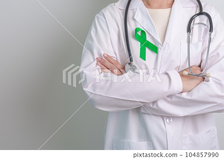 Doctor with green Ribbon for world Mental Health Day, Liver, Gallbladders, bile duct, cervical, kidney Cancer and Lymphoma Awareness month. Healthcare and world cancer day concept 104857990
