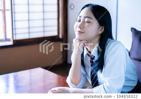 A high school girl relaxing in a Japanese-style room 104858322