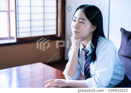 A high school girl relaxing in a Japanese-style room 104858325