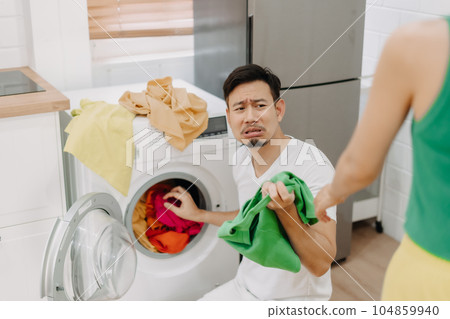 Funny crying face reaction of husband being forced to wash clothes by wife. Funny crying face reaction of husband being forced to wash clothes by wife. 104859940