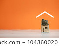 isolated ceramic home model covered by roof icon on orange background 104860020