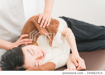 Chiropractor / therapist massaging the patient's shoulder (stiff shoulder) 104862414