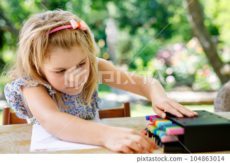 Cute Little Preschooler Child Drawing at Home. Happy Girl with Colorful Felt Pens. Hobby for Children. Leisure Activity for Small Kids. Cute Little Preschooler Child Drawing at Home. Happy Girl with Colorful Felt Pens. Hobby for Children. Leisure Activity for Small Kids. 104863014