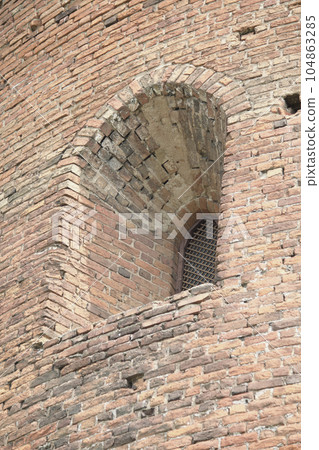 Fragments of the old fortress. From red brick. Fortress loopholes. 104863285