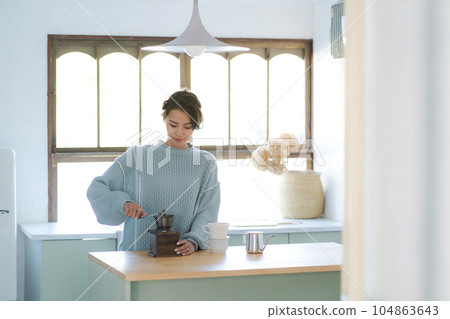 A woman who is making coffee 104863643