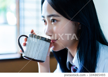 High school girl relaxing with coffee in her room 104865493