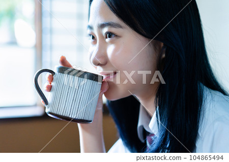 High school girl relaxing with coffee in her room High school girl relaxing with coffee in her room 104865494