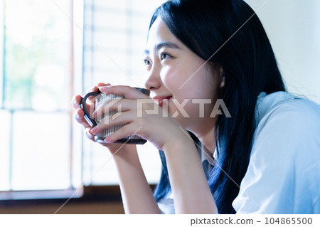 High school girl relaxing with coffee in her room 104865500