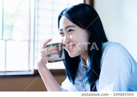 High school girl relaxing with coffee in her room 104865503