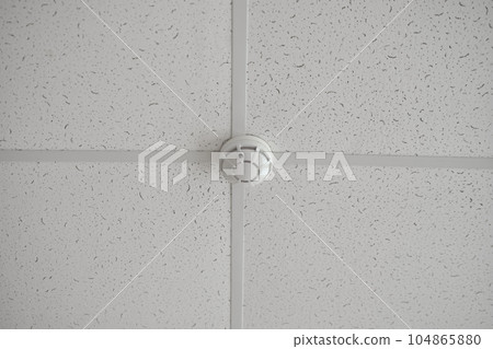 A fire sensor on the ceiling. Armstrong ceiling. A fire sensor on the ceiling. Armstrong ceiling. 104865880