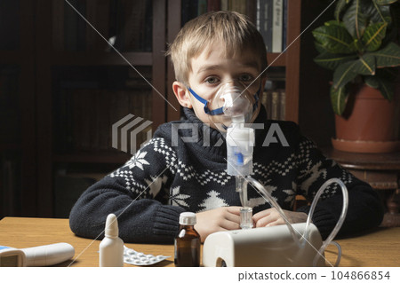 A sick child does inhalation. Inhales the medicine through the mask. Prevention of lung diseases 104866854