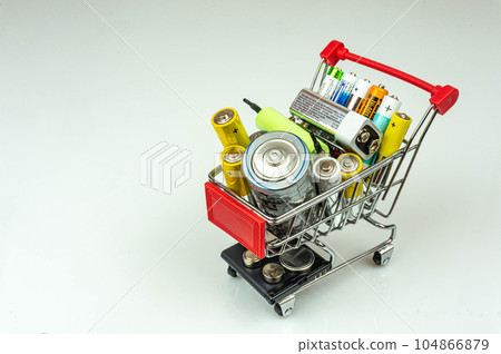 Shop cart with batteries and accumulators of different sizes. It symbolizes energy supply, utilization, electricity supply, charge. White background. Shop cart with batteries and accumulators of different sizes. It symbolizes energy supply, utilization, electricity supply, charge. White background. 104866879