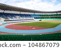 Rows of empty football stadium with green seats and blue sky in backgrounds for banners, posters, information graphics, prints layout covering books, magazine page, advertising material, advertisement 104867079