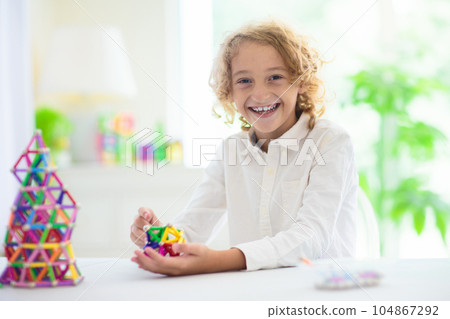 Child playing with magnetic building blocks. Child playing with magnetic building blocks. 104867292
