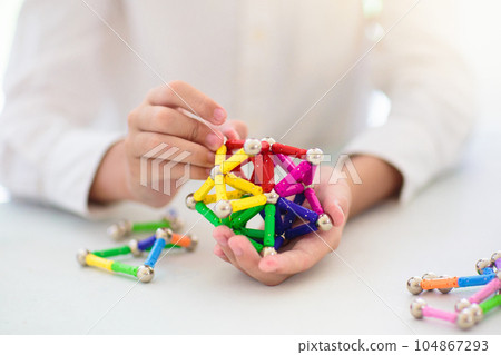 Child playing with magnetic building blocks. Child playing with magnetic building blocks. 104867293