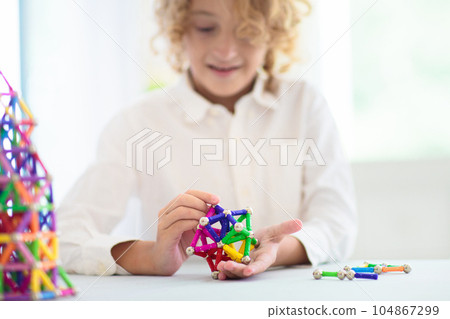 Child playing with magnetic building blocks. Child playing with magnetic building blocks. 104867299