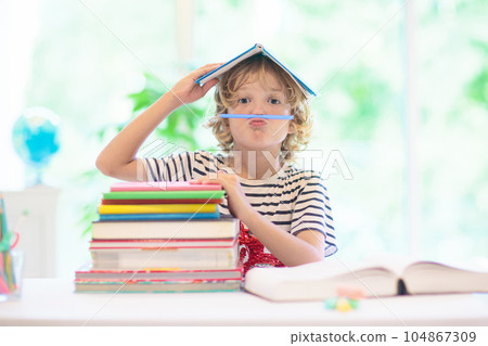 Child with books doing homework after school. Child with books doing homework after school. 104867309