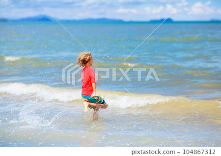 Kids play on tropical beach. Sand and water toy. Kids play on tropical beach. Sand and water toy. 104867312