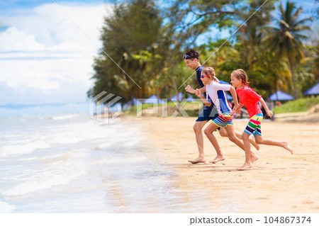 Kids play on tropical beach. Sand and water toy. 104867374