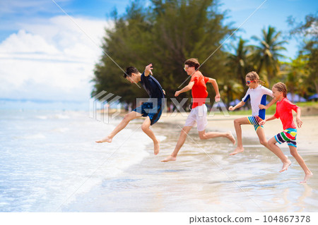 Kids play on tropical beach. Sand and water toy. 104867378