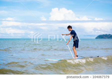 Child on stand up paddle. Water and beach sport 104867379