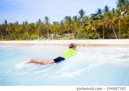 Surfer on tropical beach. Boy surfing. 104867382