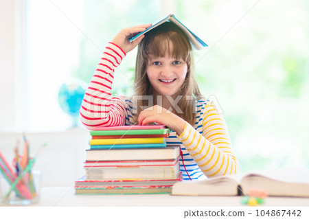 Child with books doing homework after school. 104867442