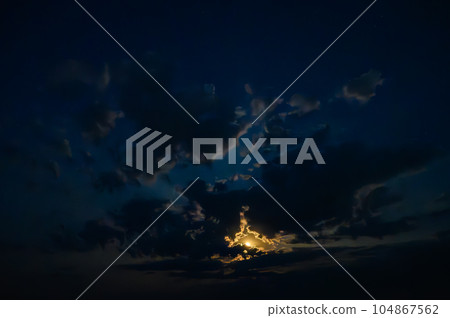 Moon in the clouds in the night sky Moon in the clouds in the night sky 104867562